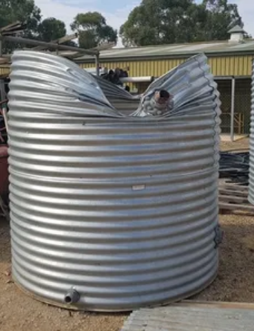 Large corrugated galvanised rainwater tank installed on site